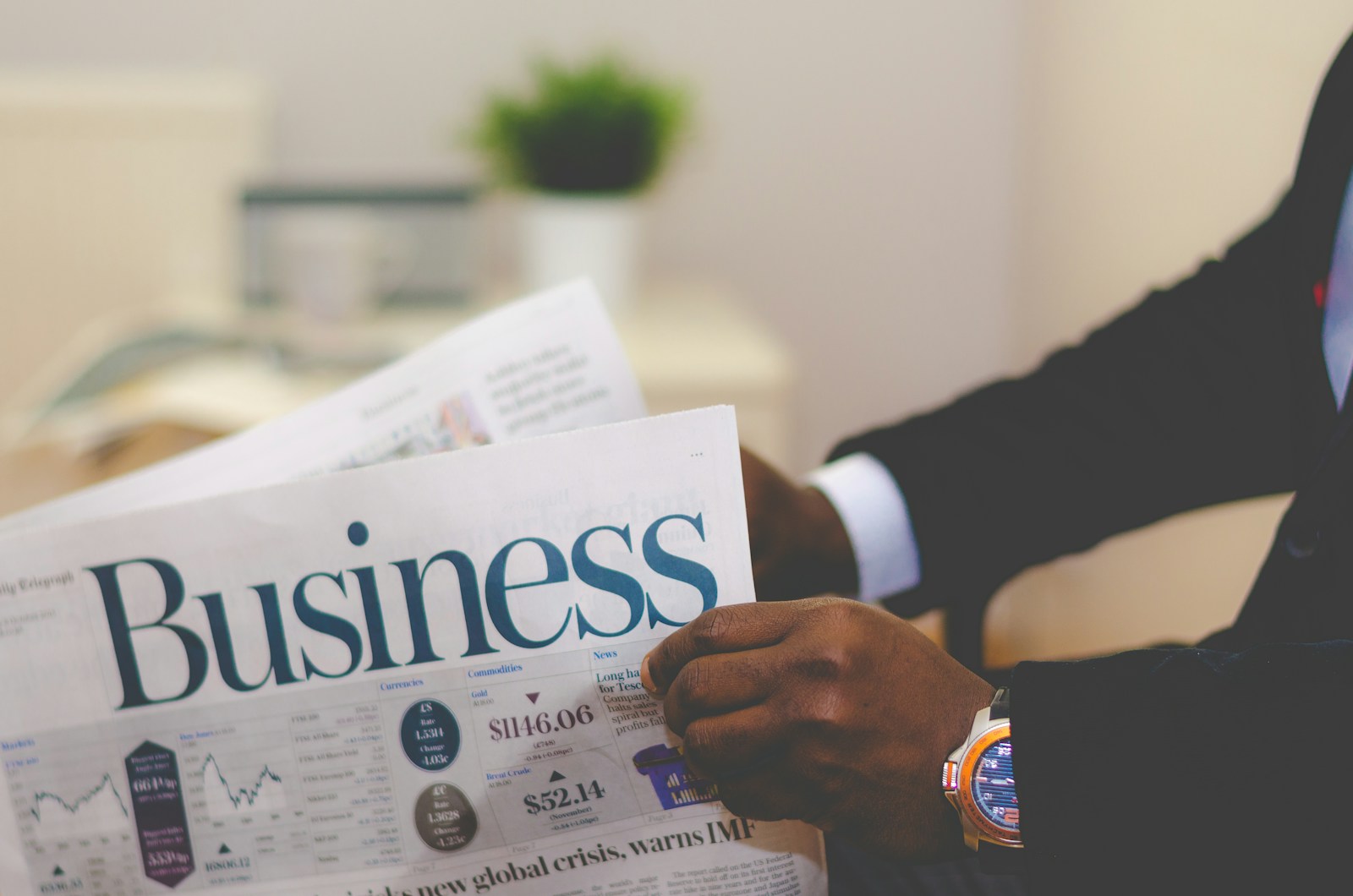 person wearing suit reading business newspaper, business